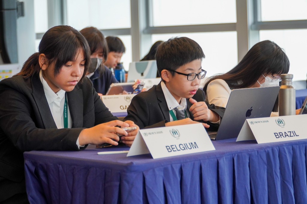 Delegates at Belgium–Brazil table with laptops