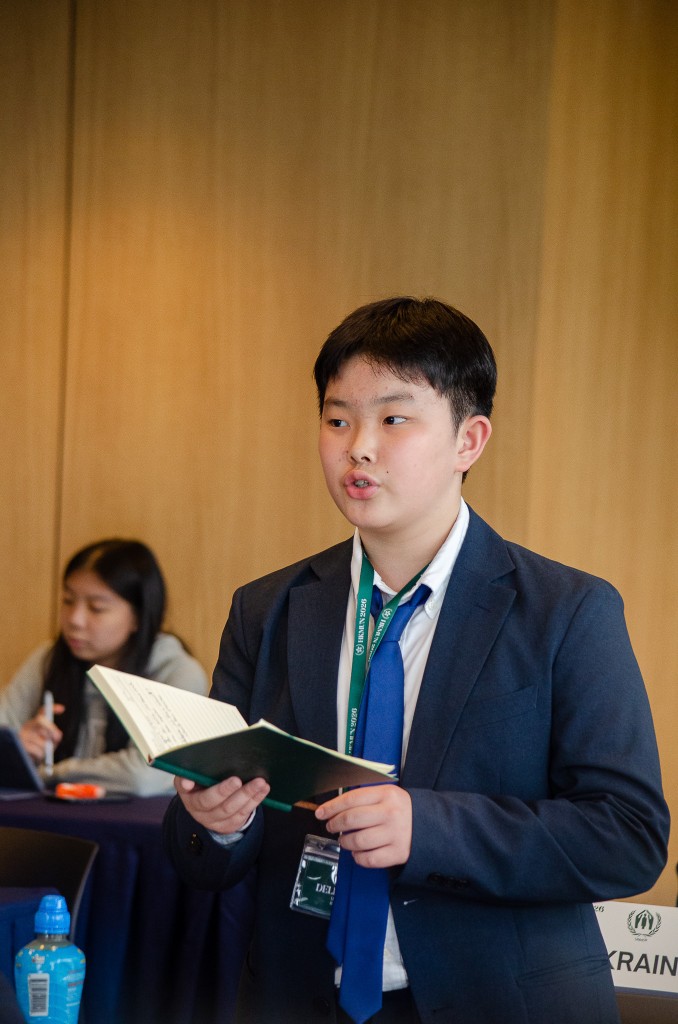 Delegate speaking while holding notebook